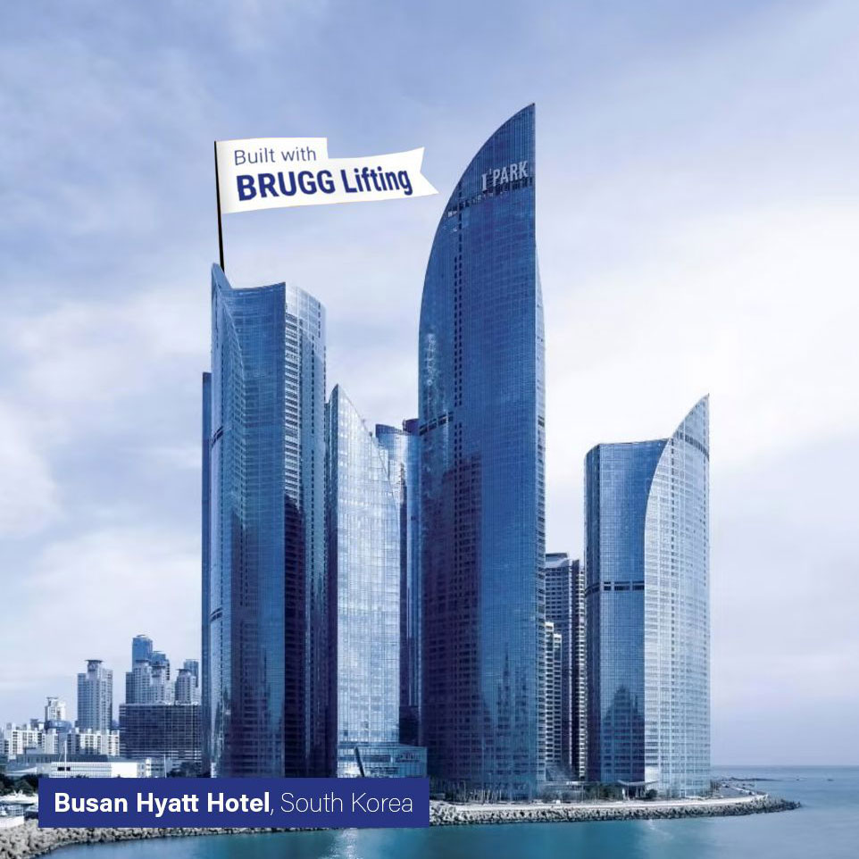 Auf Landzunge mehrere Hochhäuser mit Glasfronten. Links eine grafische weiße Fahne mit der blauen Aufschrift:"Built with BRUGG Lifting". Unten links blauer Banner mit der weißen Aufschrift: "Busan Hyatt Hotel, South Korea".